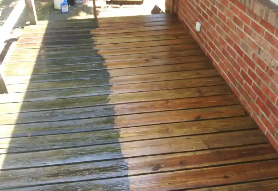 A wooden deck half pressure washed, clean boards beside weathered grey ones